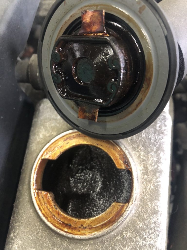 The back of the engine oil cap that has accumulated sludge